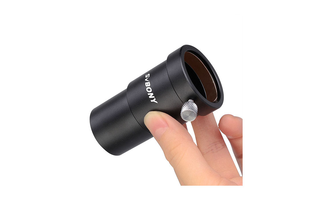 Black telescope eyepiece held by a hand on a white background