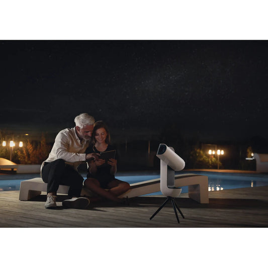 couple sitting by a swimming pool using the app for the Vespera